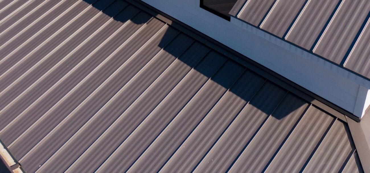 Close-up of a standing seam metal roof with raised panels installed on a residential home.